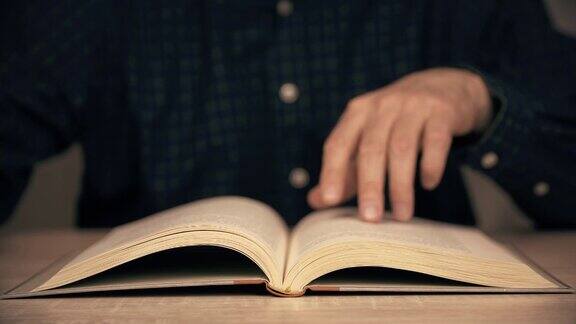 男性在近距离阅读时用手翻动书页人阅读的书