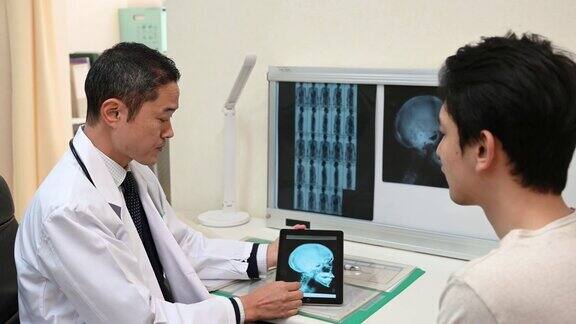 日本医生给病人看数字平板电脑上的x光片