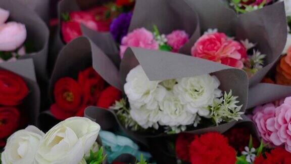 时尚的彩色玫瑰花束在纸在花店