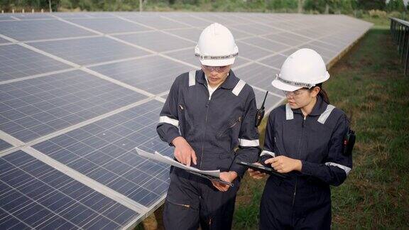 太阳能电池板电站电气工程师检查建筑外的太阳能电池场