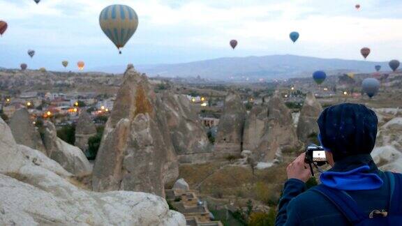 摄影师正在卡帕多西亚的戈雷米拍摄热气球充气的照片