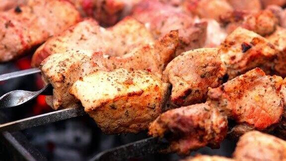 烤肉上烤制美味菜肴的特写在大自然中烹饪美味烤肉的过程美味的食物串在金属烧烤是时候野餐了街头食品美食节木桩上的猪肉