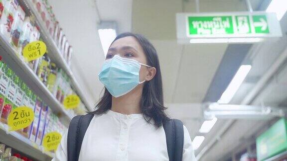 亚洲妇女戴着防护口罩在超市购物