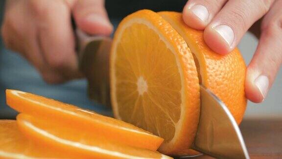 男手拿着大刀在厨房的砧板上切橘子在家中近距离观看甜点的制作过程