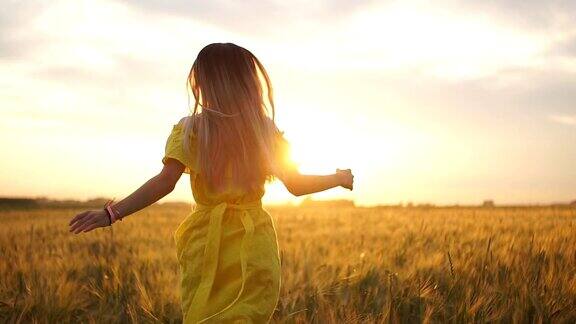 一个穿着黄色衣服留着长发的年轻女孩在麦田里奔跑慢动作
