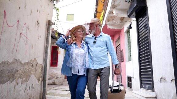 一对可爱的老年夫妇走过城市街道四处张望