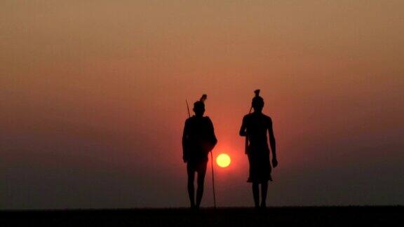 布须曼人在Makgadikgadipan的夕阳下行走