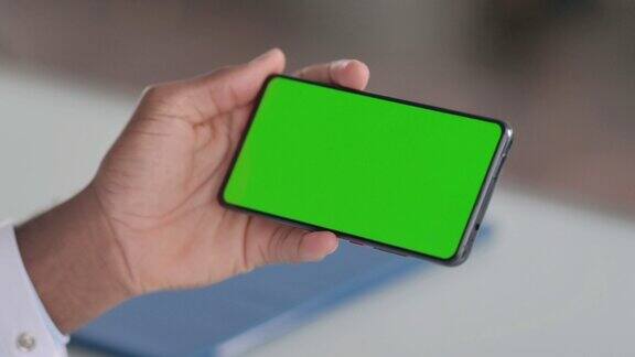 男子手持智能手机与绿色色度键屏幕