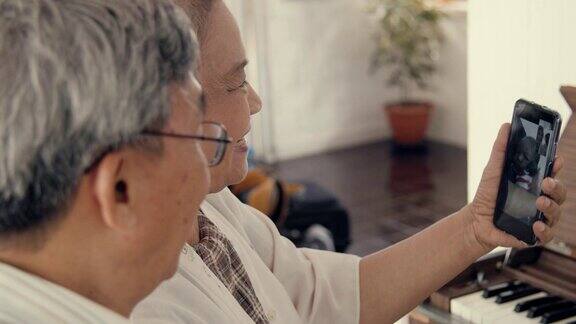 一对老年夫妇用智能手机和孙子聊天