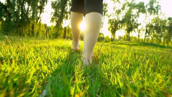 夏天的时候女人的脚走在草地上