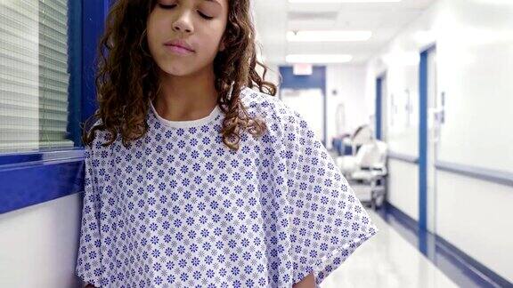沮丧的少女站在医院走廊