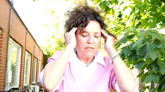 痛苦的成熟的白人女性在她的阳台上遭受头痛4k