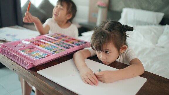 两个女孩在木桌上画画