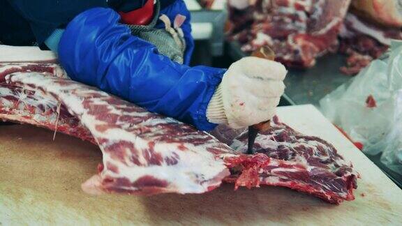 一名工人在肉类包装厂切肉
