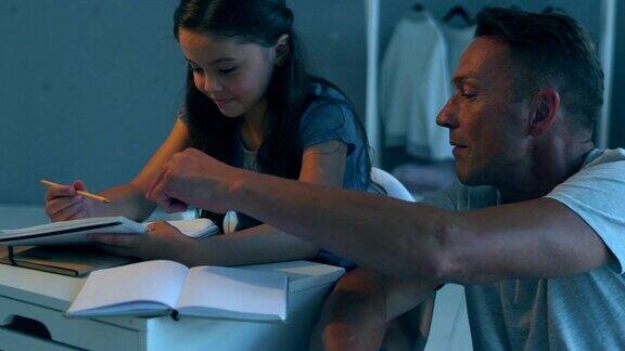 积极的父亲帮助他的小女儿完成家庭作业