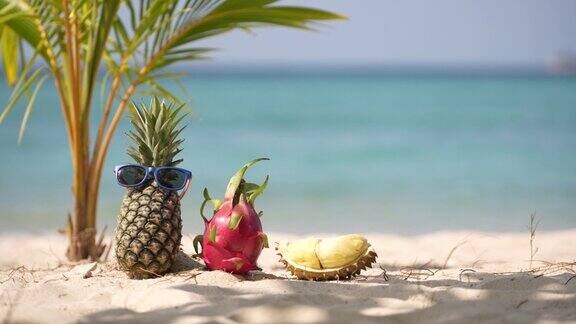 在海边的沙滩上放着成熟的菠萝和粉红色的火龙果