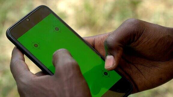 一个年轻人在用绿色屏幕的智能手机