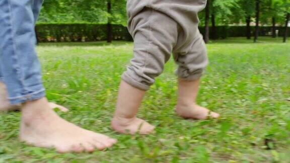 母亲和婴儿赤脚走在草地上