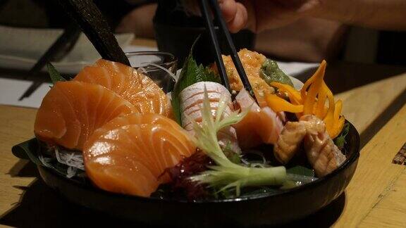 吃什锦三文鱼生鱼片美丽的日本料理