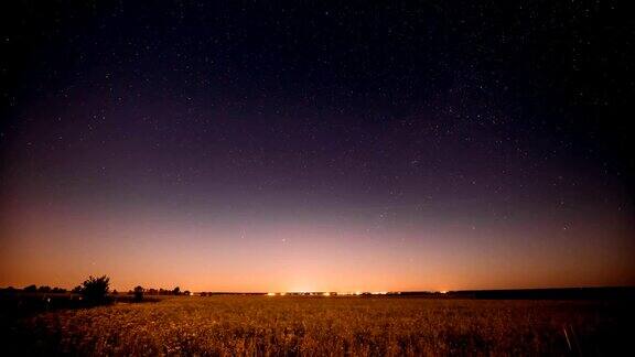 自然之夜夏日草地上的星空发光的星星和日落日出的灯光之上的景观