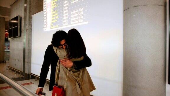 年轻女子在机场欢迎和拥抱商人