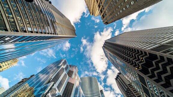 4K时间流逝芝加哥市中心摩天大楼的上升角度与高楼之间的云反射伊利诺伊州美国商业和透视概念