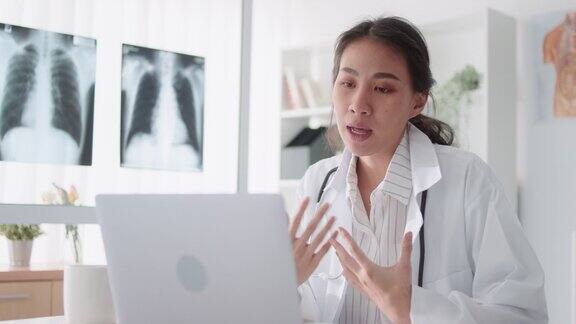 亚洲女医生使用笔记本电脑在线视频远程与病人通话开药远程医疗、远程保健、医院诊所保健服务或互联网技术概念