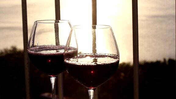 在阳台上往玻璃杯里倒红酒