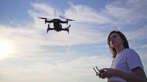 一个女飞行员在美丽的日落时分操控无人机飞离地面