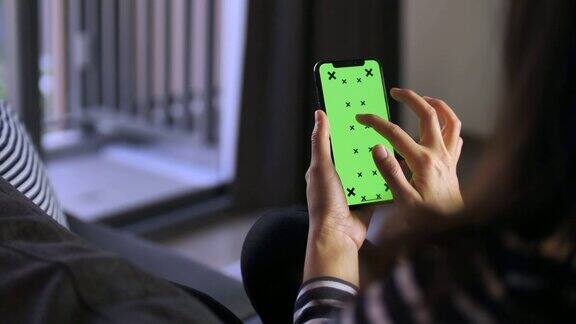 手持绿色屏幕智能手机的女性