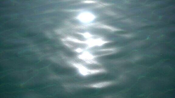 由太阳引起的闪亮水面的慢镜头特写