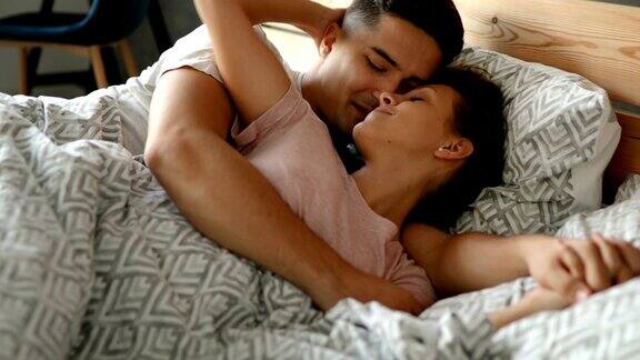 年轻幸福的夫妇在卧室里拥抱