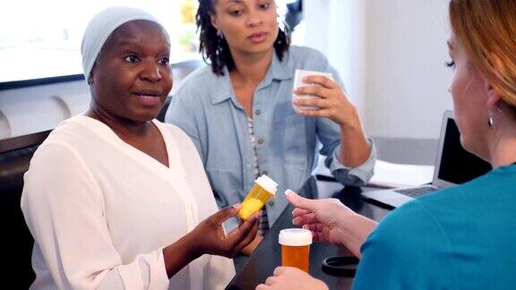 家庭护理护士向老年女性病人解释药物副作用