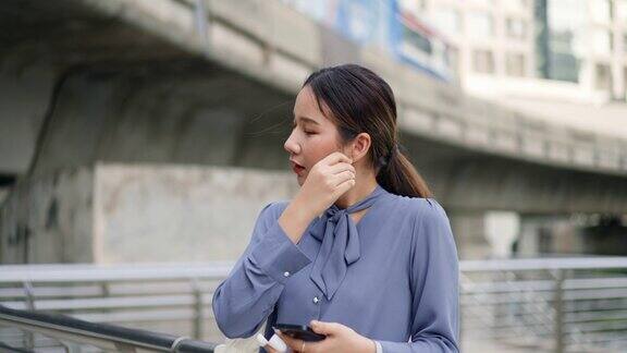 女商人愉快地使用蓝牙耳机