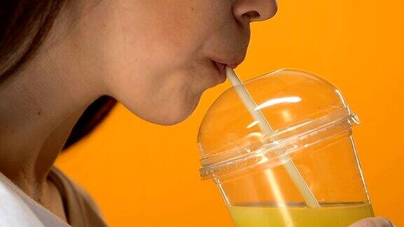 口渴的女士喝新鲜橙汁健康的生活方式排毒饮食特写