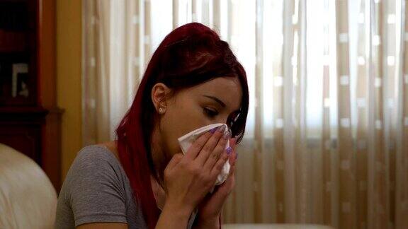 十几岁的生病女孩打喷嚏感冒抓着她疼痛的喉咙用纸巾擤鼻子