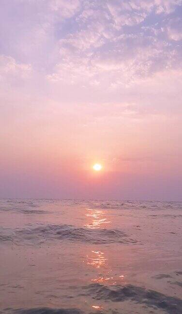 海滩上的夕阳和粉红色的云彩