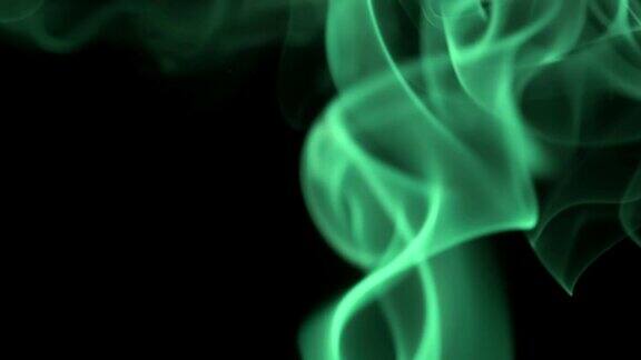 细细的霓虹绿烟缓缓升起优雅地盘旋在黑色的背景上彩色烟雾从下往上飘特写镜头