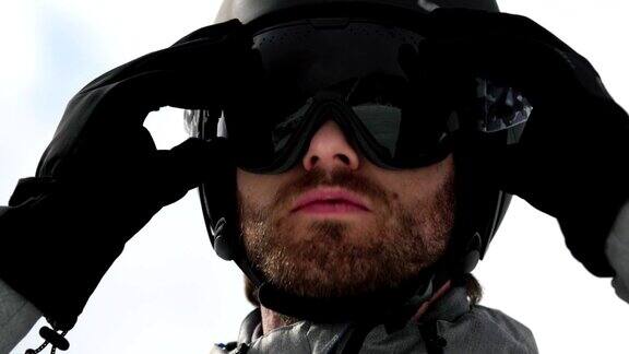 男子脸部细节与头盔把太阳面具准备滑雪登山滑雪活动冬季滑雪者在高山户外运动前视图慢动作60p4k视频