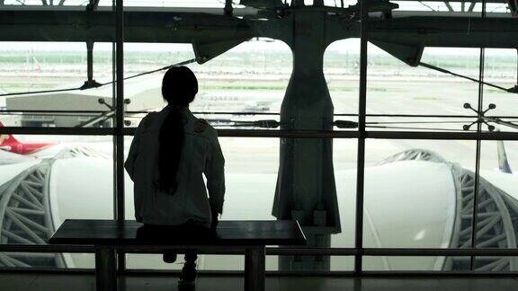 年轻的亚洲女性在机场用智能手机检查航班准备旅行
