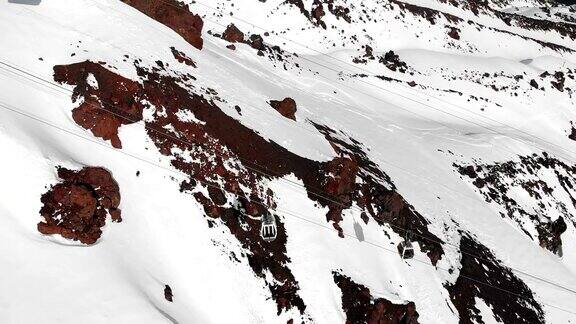 鸟瞰图的缆车和滑雪坡道在高加索的高山在度假胜地厄尔布鲁斯在冬季跟踪小屋索道