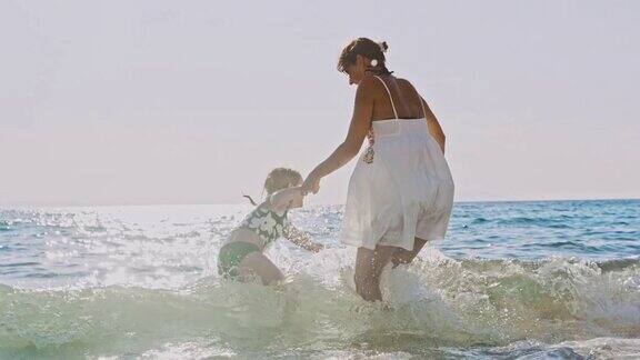母亲和女儿跳过海浪
