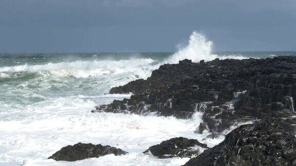 慢镜头:海浪拍打着岩石北爱尔兰巨人的堤道