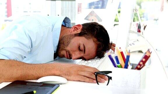 困倦的设计师在办公桌上睡着了
