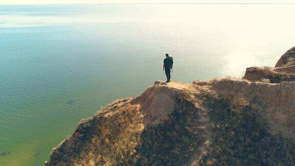 旅行者站在山崖上背景是海景