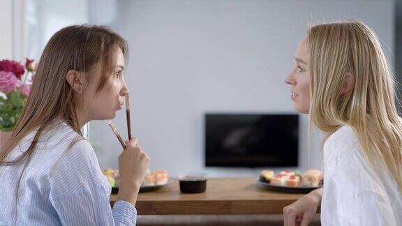 两个女孩朋友坐在屋子里闲聊吃寿司送上门