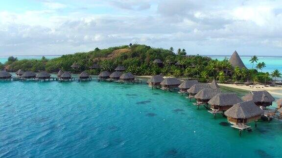AERIAL:豪华的私人岛屿度假村在太平洋的小隐蔽的motu岛上有豪华的水上别墅和专属的海滨别墅