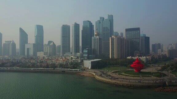 阳光灿烂的日落青岛市区著名的海湾广场航拍全景4k中国