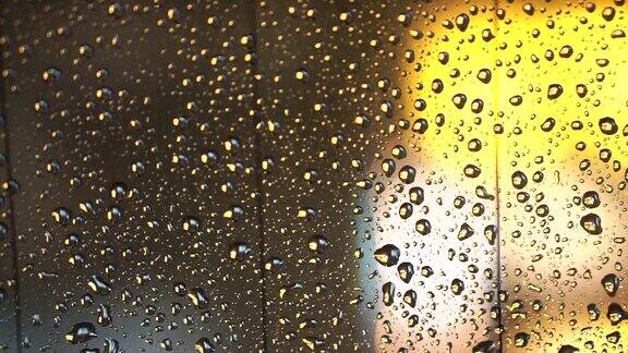 金光散焦雨点落在窗玻璃上