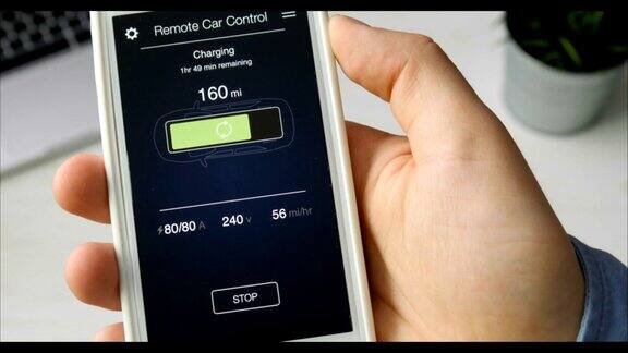 男子检查他的汽车充电水平使用智能手机应用虚拟接口远程控制汽车充电